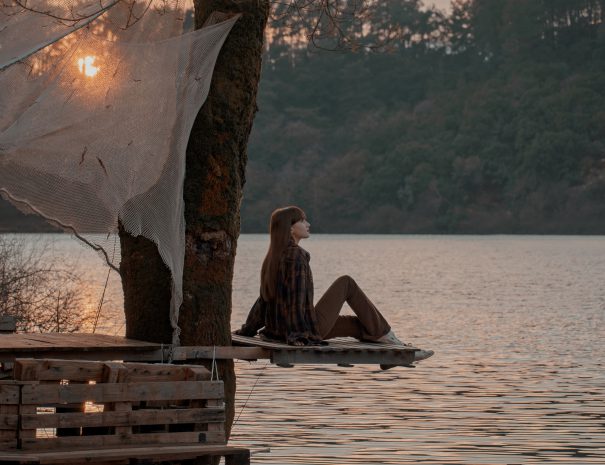 rear-view-woman-standing-by-lake-min
