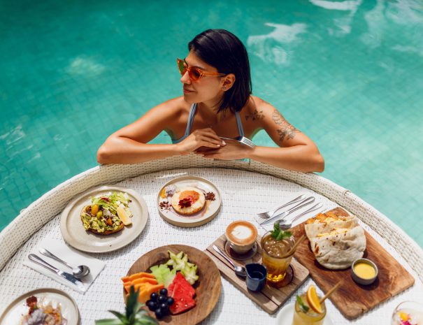 young-sexy-woman-with-tattoo-bathing-suit-having-breakfast-private-pool-girl-relaxing-pool-drinking-coffee-eating-fruits-fruit-plate-smoothie-bowl-by-hotel-pool-min